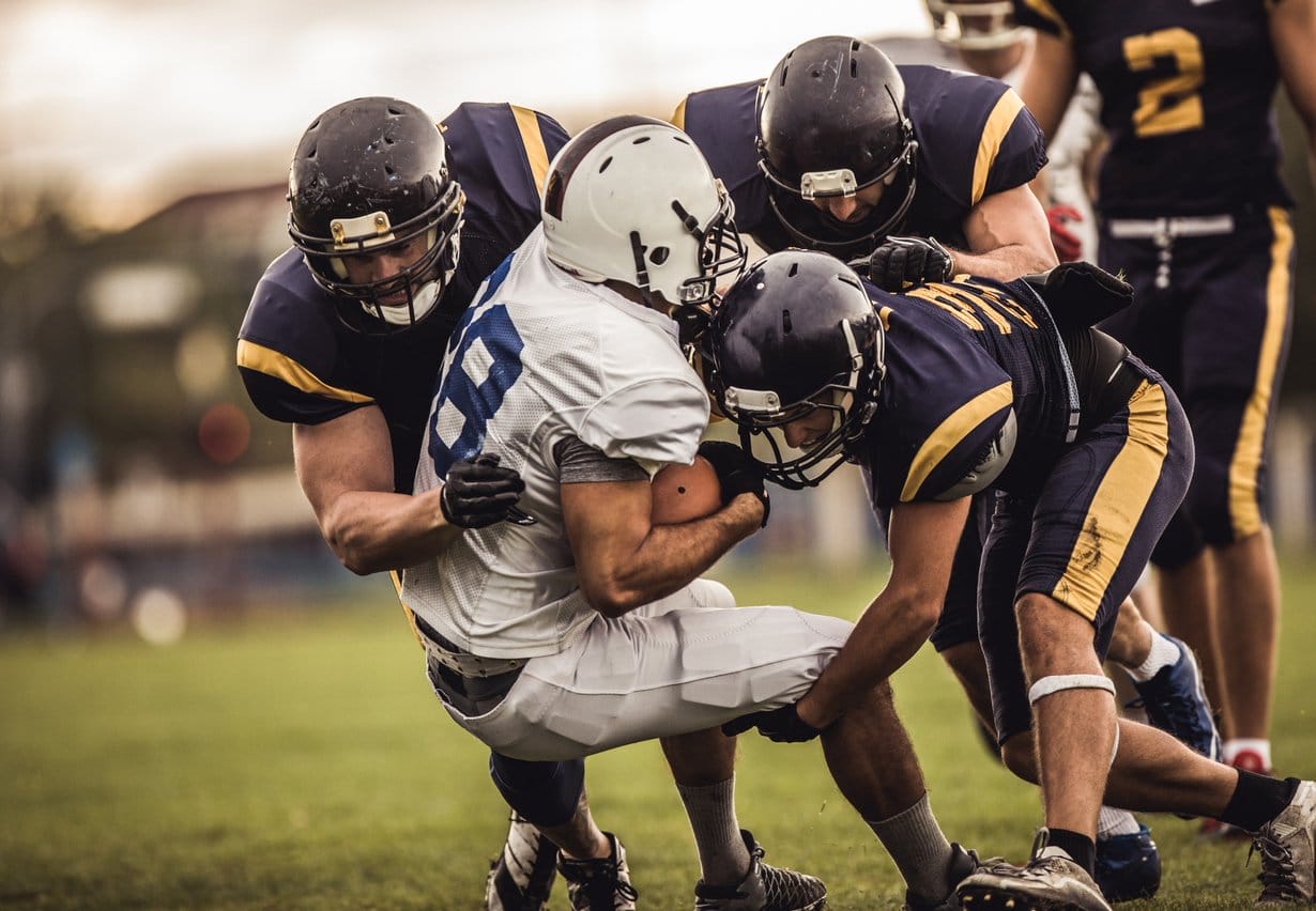 Football Player getting tackled by