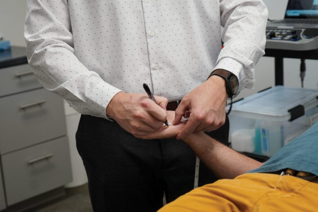 Doctor measuring patients hand for EMG